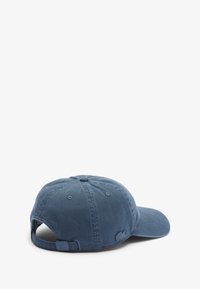 Gorra de béisbol de algodón azul con visera curva, correa ajustable en la parte posterior y logotipo bordado en el lateral. Textura suave y diseño casual.