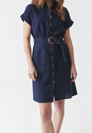 Granatowa lniana sukienka koszulowa z krótkimi rękawami, zapinana na guziki z przodu, z wiązanym paskiem w talii ozdobionym okrągłym akcentem.
