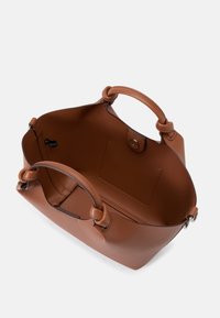Geantă de mână din piele maro, cu o finisare texturată, având două mânere în formă de buclă, un interior spațios și o închidere tip snap. Interiorul are un buzunar tip slip.