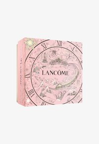 Boîte cadeau rose présentant un motif d'horloge, avec des chiffres romains noirs et des illustrations complexes de paysages d'hiver et de monuments. "Lancôme" en texte gras.