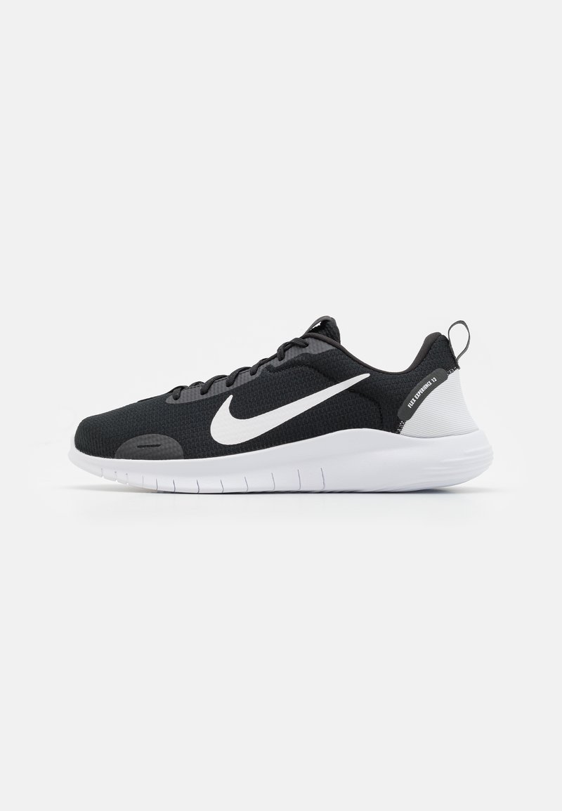 Chaussure de sport noire avec tige en maille, logo Nike swoosh blanc, accents texturés et semelle en caoutchouc blanche. Dispose d'une languette au talon.