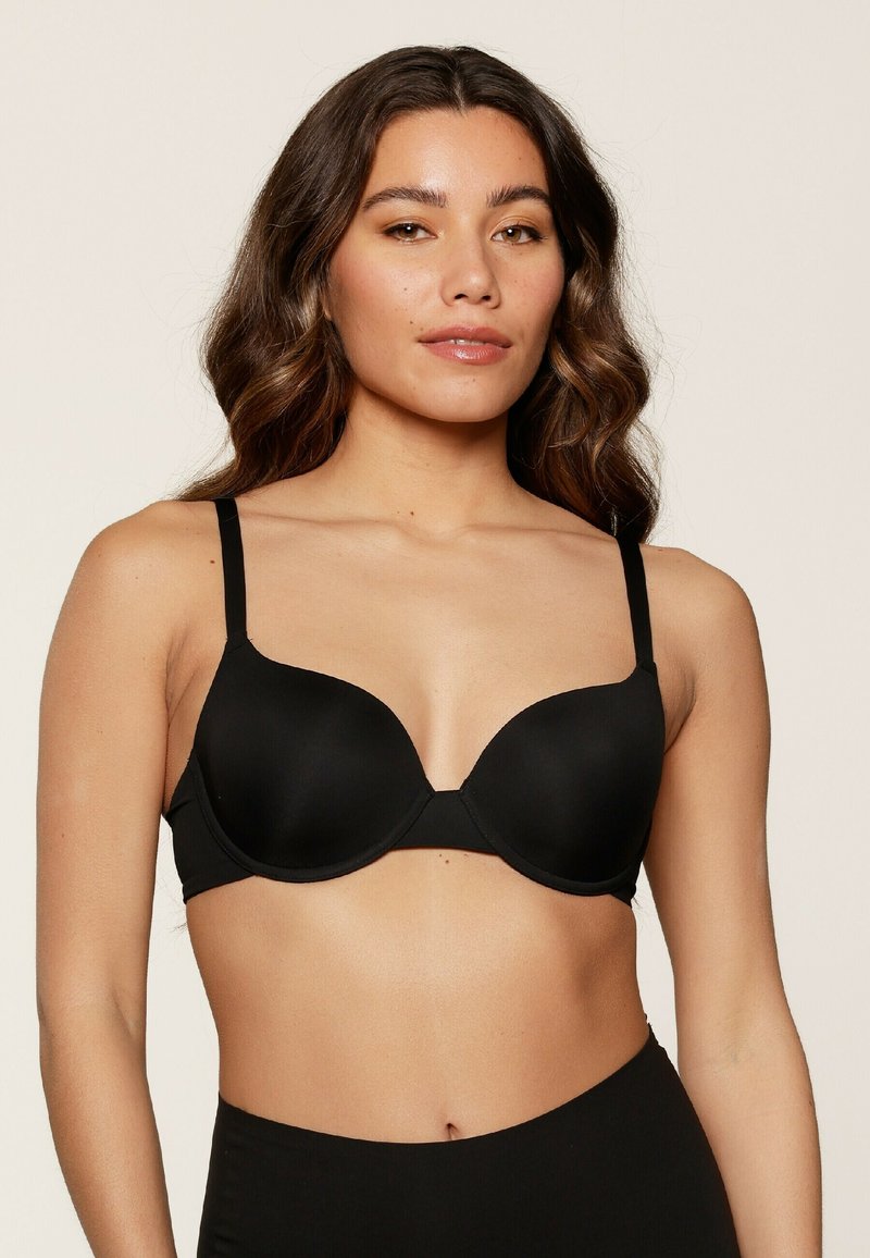 Bra imbottito nero con spalline regolabili, design senza cuciture e supporto con ferretto. Texture liscia e costruzione minimalista per il comfort.