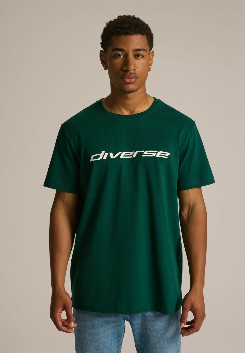 Zielona bawełniana koszulka z krótkim rękawem, z białym napisem "diverse" na piersi. Prosty krój, klasyczny design, z okrągłym dekoltem.