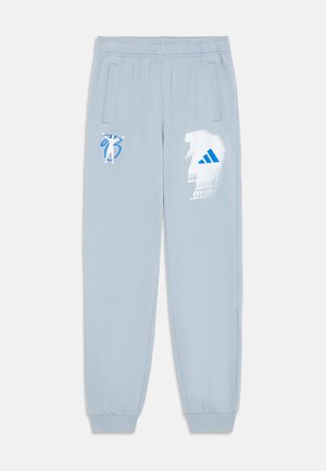 Helle blaue Sweatpants mit einem Zugbandbund, seitlichen Taschen und gerippten Bündchen. Mit einem weißen und blauen Grafikdesign an einem Bein.