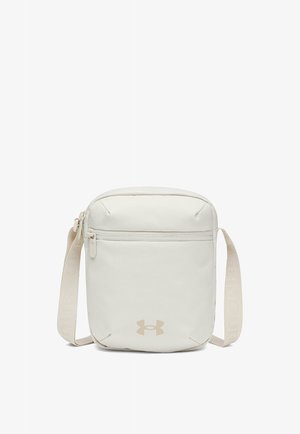 Kleine beige crossbodytas met voorvak met rits, verstelbare band en Under Armour-logo aan de onderkant middenvoor.