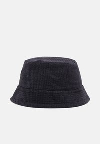 Czarny kapelusz typu bucket z kordurowej tkaniny, charakteryzujący się miękkim, teksturowanym wykończeniem, okrągłą koroną i szerokim rondem, zapewniającym ochronę przed słońcem.