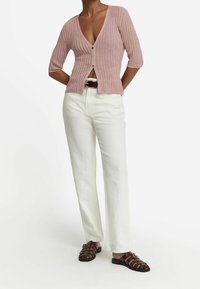 Light pink ribbed knit cardigan with a deep V-neck, three-quarter sleeves, and buttons at the front, paired with white wide-leg trousers and brown sandals.