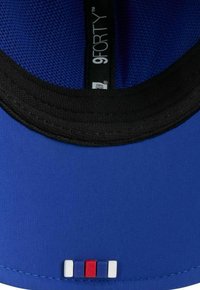 Blaues Baseballcap mit einem Netz-Innenfutter. Verfügt über ein schwarzes Schweißband und einen kleinen farbigen Akzentblock in Rot, Weiß und Blau auf der Innenseite.