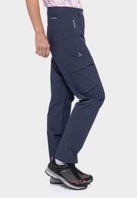 Marineblaue Cargo-Hosen mit zwei Seitentaschen, einer Frontzippertasche und schmaler Passform. Hergestellt aus strapazierfähigem, leichtem Material mit glatter Textur.