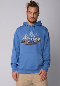 Haut à capuche bleu avec une poche avant présentant un graphique de montagne géométrique dans des tons de gris, marron et orange. Matériau doux, manches côtelées.