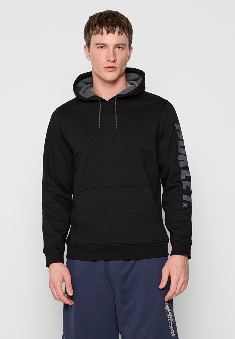 Sudadera negra con capucha, con un interior gris. Gran logo de "Hurley" en gris en la manga izquierda, bolsillo tipo canguro en la parte frontal.