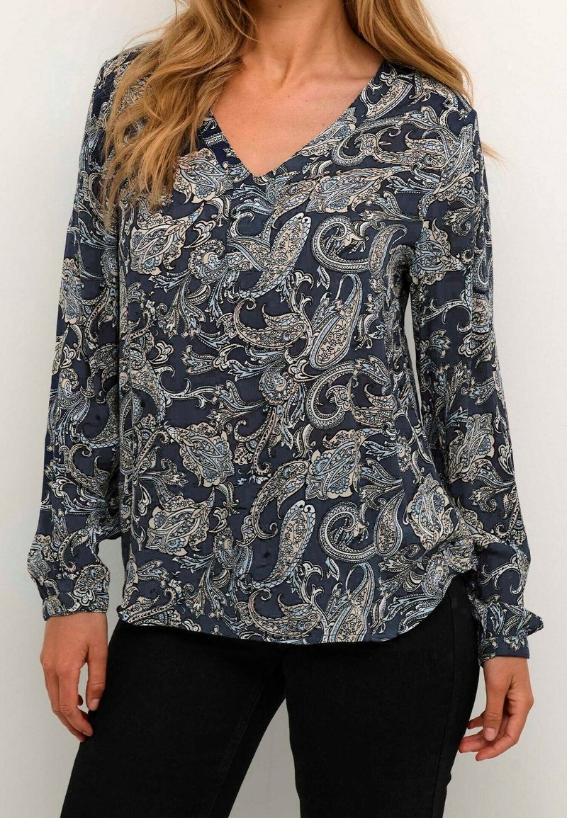 Blusa a maniche lunghe di colore blu navy con motivo paisley in azzurro chiaro e crema. Design a V con una texture morbida. Vestibilità fluida.