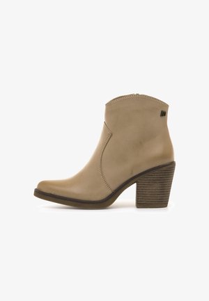 Stivale alla caviglia in pelle beige con punta affusolata, una cerniera corta sul lato e un tacco impilato texturizzato. Presenta cuciture semplici e accenti minimali.