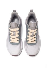 Zapatillas deportivas grises con parte superior de malla, punta redonda, cordones crema y un patrón texturizado. Incluyen una lengüeta y un logotipo en contraste en el costado.