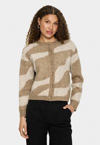 Brūnas un krēmkrāsas rakstainā džemperis ar noapaļotu apkakli, pogu aizdari un ribotām piedurknēm. Izgatavots no mīksta, teksturēta dzijas.