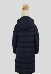 Námořnická puffer bunda s kapucí, se strojově prošívanými vodorovnými sekcemi. Doplněna krémovou pletenou čepicí s umělou kožešinovou bambulí.