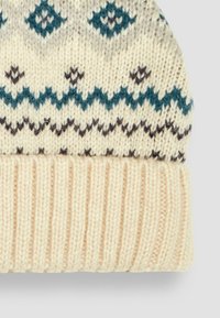 Strikket hue i creme med et mønsterdesign, der har teal og mørkebrun accenter, ribbet kant i bunden, blød tekstur.