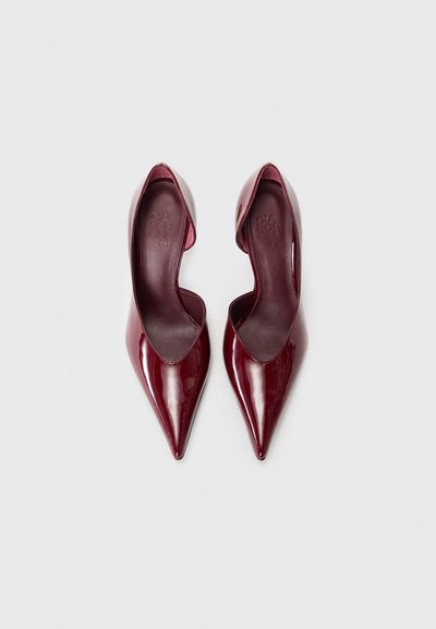 Burgundy patent leather high-heeled shoes with a pointed toe and a deep cut design on the sides. Smooth texture with a glossy finish.