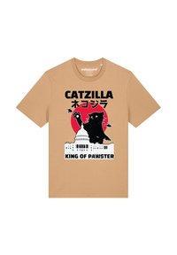 Crème kleurige t-shirt met een afbeelding van een zwarte kat die op een monster lijkt, tegen een rode cirkel, met de tekst "CATZILLA" en "KING OF PAWSTER."