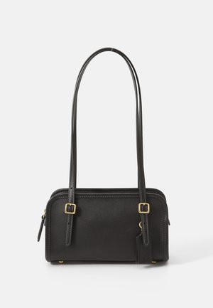 Fekete bőrtáska karcsú, téglalap alakú, két kerek fogantyúval, arany színű fémalkatrészekkel és egy oldalsó cipzáras zsebbel.