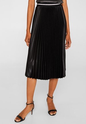 Schwarzer plissierter Midirock aus glänzendem Stoff mit strukturierter Oberfläche, ausgestattet mit einem elastischen Bund und fällt unter das Knie.