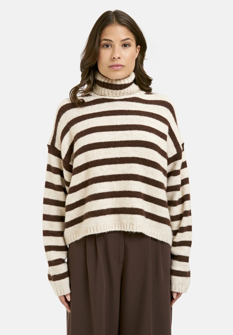 Striped turtleneck sweater in cream and brown hues. Soft knit fabric, oversized fit, and ribbed hem. Features dropped shoulders and long sleeves.