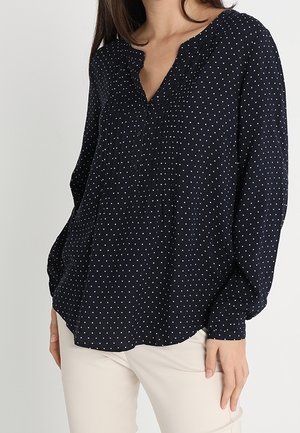 Navyblaue Bluse mit weißen Punkten, mit langen Ärmeln, einem gefältelten Vorderteil und einem V-Ausschnitt. Leichter Stoff mit lockerer Passform.