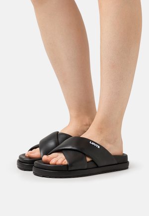 Zwarte schuifsandalen met een kruisbandontwerp, gemaakt van glad synthetisch materiaal, met een gestructureerde zool en logo-detail.