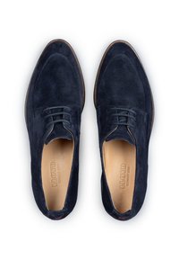 Donkerblauwe suède schoenen met een afgeronde neus, vetersluiting en lichtbruine leren binnenzolen. Voorzien van een subtiel stiksel en een rood accent.