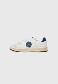 Hvite skinn sneakers med en teksturert blå aksent på siden, rund emblem og svart gummisåle. Inkluderer snøringer og merkevaredetaljer.