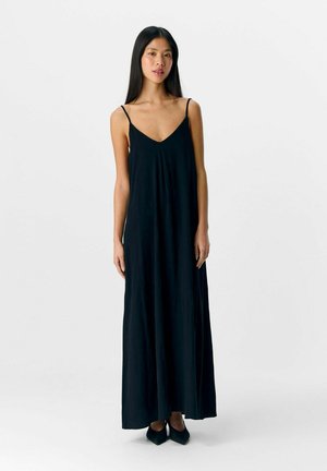 Zwarte maxi-jurk met dunne bandjes, een V-halslijn en een vloeiende silhouet. Soepele stoftextuur en minimalistisch ontwerp.