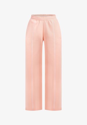 Pantalones de chándal anchos de color rosa claro, con una textura suave, cinturilla elástica y detalle de ribete blanco a los lados. Diseño simple y cómodo.