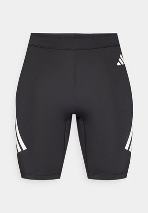 Musta urheilushortsit, joissa on istuva leikkaus. Sivulla on kolme valkoista raitaa ja takaosassa pieni logodetalji. Sileä pinta.