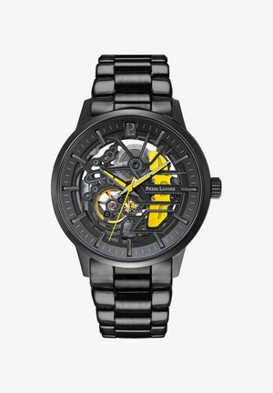 Reloj esqueleto negro con un dial transparente que muestra la mecánica interior, acentos amarillos y una pulsera de metal cepillado.