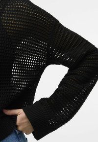 Zwarte gebreide trui met een open gaasontwerp op de mouwen en schouders, voorzien van geribbelde boorden en een ontspannen pasvorm.