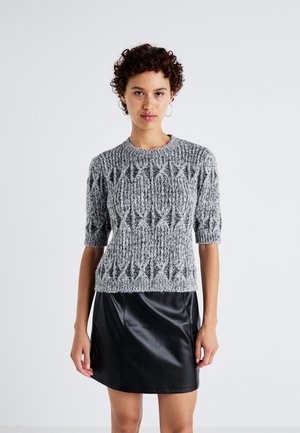 Maglione grigio a maglia con maniche corte e motivo a rombi testurizzati, abbinato a una mini gonna nera in pelle. Aspetto morbido e accogliente.