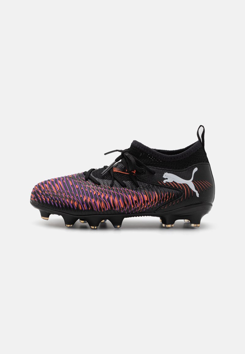 Chuteira de futebol preta com um material texturizado apresentando padrões em zigzag roxos e laranjas, fecho de atacadores e sola de borracha moldada com cravos.