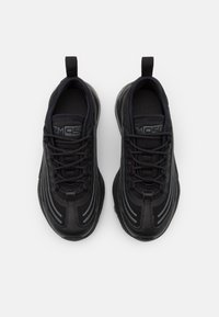 Svarta träningssneakers med en texturerad ovandel, som har tonmatchande skosnören, dragflikar och subtila ljusgrå detaljer längs sidorna.