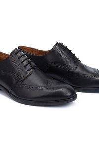 Le scarpe da uomo in pelle nera presentano un design a wingtip, dettagli perforati e sei occhielli per i lacci. Texture liscia con una forma della punta arrotondata.