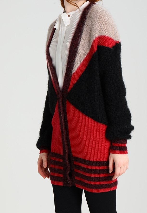 Stickad cardigan i blockfärgerna röd, svart och beige, med ribbad textur, långa ärmar och knäppning framtill.