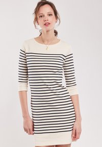 Abito a strisce con strisce orizzontali blu navy e crema, scollo rotondo e maniche a tre quarti in uno stile aderente.