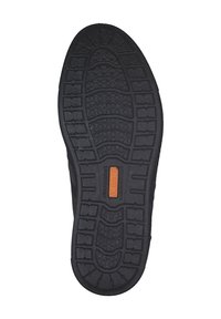 Semelle de chaussure en caoutchouc noir avec un motif de grip texturé, présentant un logo central orange. Légère courbure au niveau du talon pour un ajustement ergonomique.