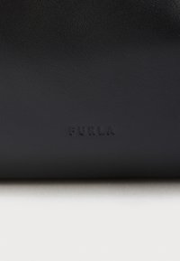 Portofel negru din piele cu o textură netedă, cu litere tip bloc "FURLA" embossate pe față. Design curat și minimalist.