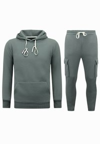 Hoodie en joggers set in gedempt groen, met een kangoeroezak, trekkoorden en cargozakken op de broek. Materiaal van katoenmix.