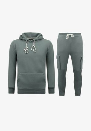 Hoodie en joggers set in gedempt groen, met een kangoeroezak, trekkoorden en cargozakken op de broek. Materiaal van katoenmix.
