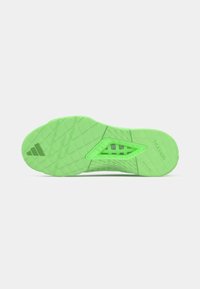 Semelle de chaussure de sport verte présentant une texture antidérapante, des motifs triangulaires et un logo. Matériau léger avec des découpes pour plus de flexibilité.