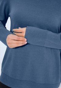 Modrý pletený svetr s dlouhými rukávy, s žebrovanými manžetami a texturovaným vzorem na lemu. Hladká tkanina, volný střih.