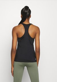 Musta urheilullinen toppi, jossa on racerback-muotoilu, valmistettu kevyestä kankaasta. Ominaisuuksiin kuuluu sileä rakenne ja minimaalinen brändäys helman kohdalla.
