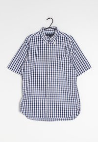 Camisa de manga corta con botones en un patrón de cuadros en azul marino y blanco, con un bolsillo en el pecho y un cuello clásico. Hecha de tejido ligero.