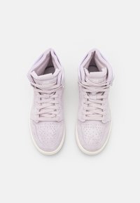 Paire de baskets montantes violet clair avec lacets, bouts perforés et col rembourré, vues de dessus sur un fond clair.